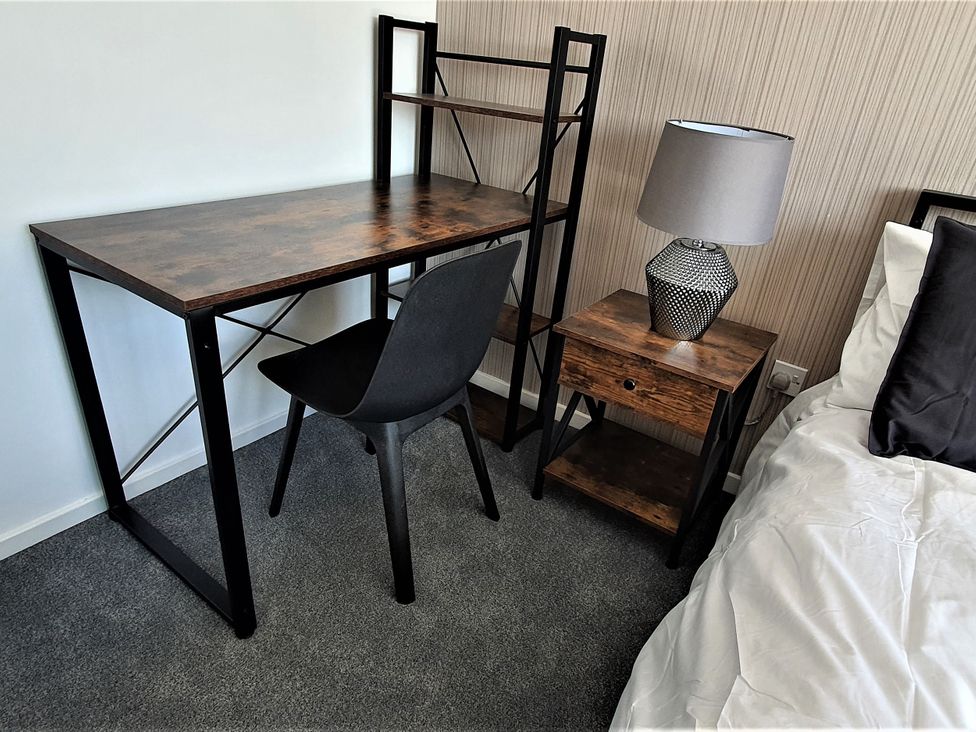 A bedroom with a desk and chair at 32 Moorland House