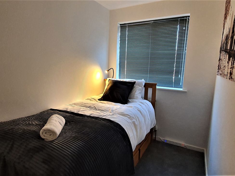 A bedroom with a single bed and window at 32 Moorland House