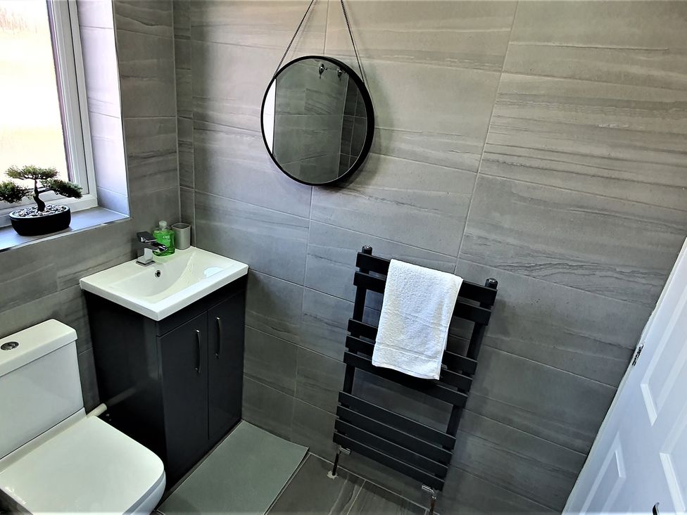 A bathroom with a sink, toilet, and mirror at 32 Moorland House