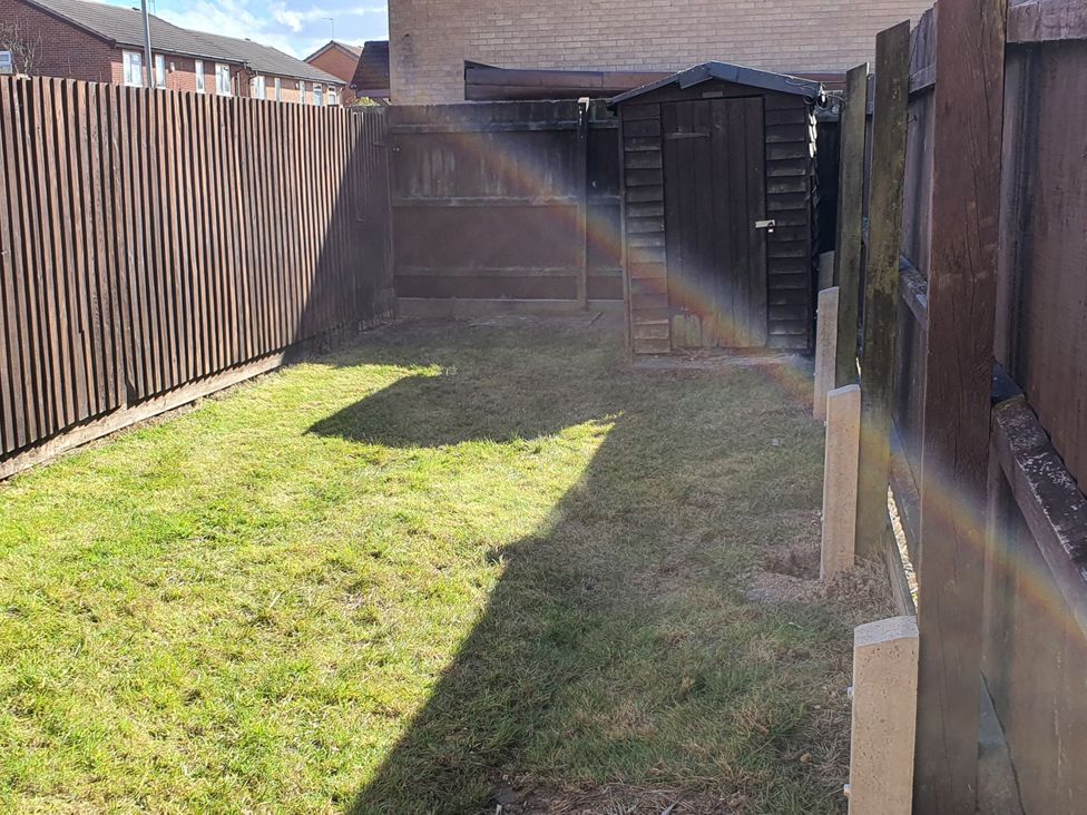 A garden with a grass area and wooden fence at 32 Moorland House 