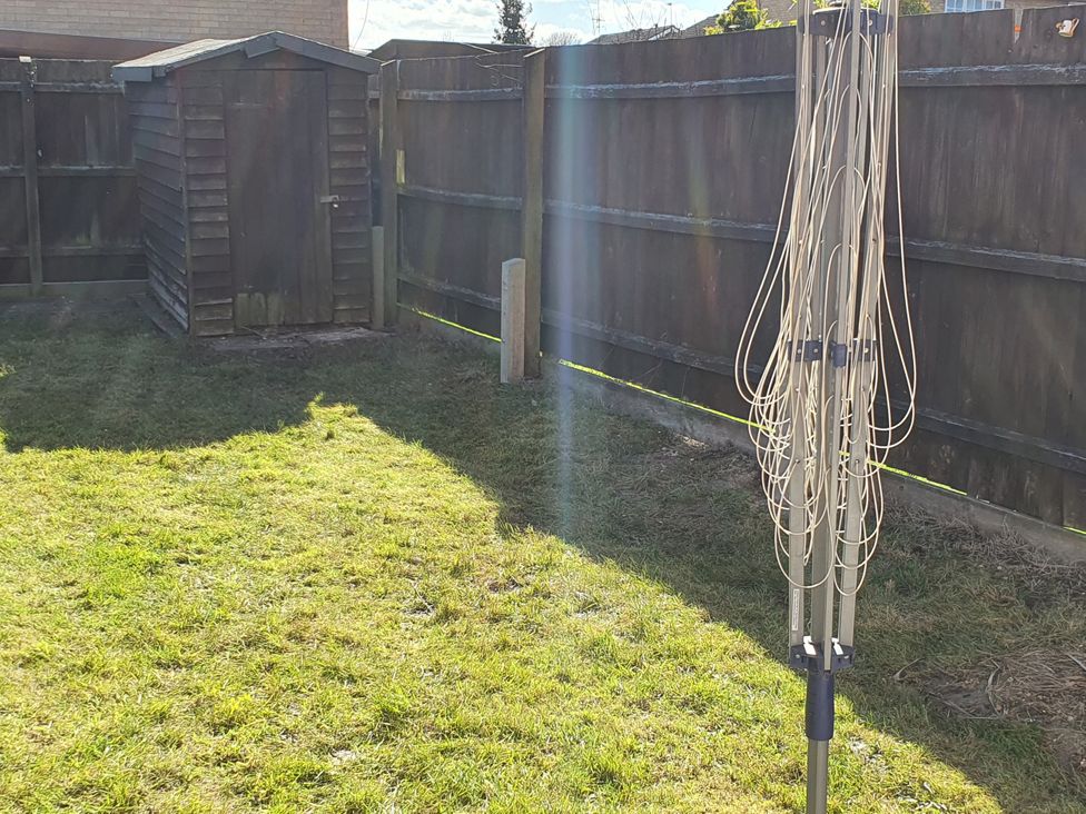 A garden with a shed and a clothes line at 32 Moorland House