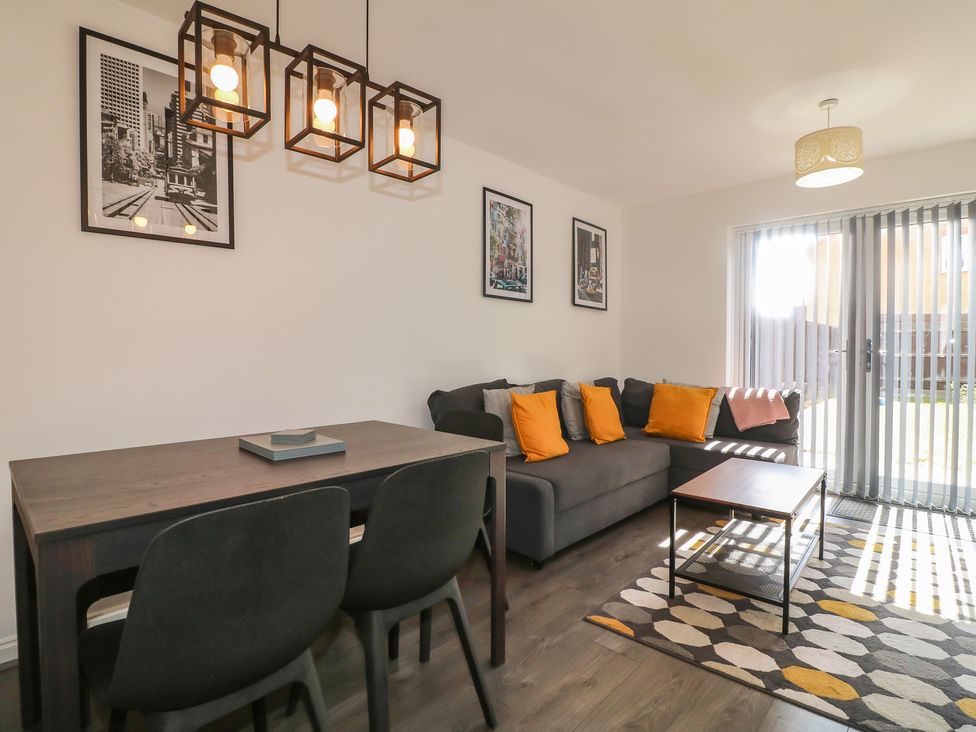 A living room with a sofa and dining table at 32 Moorland House Syston