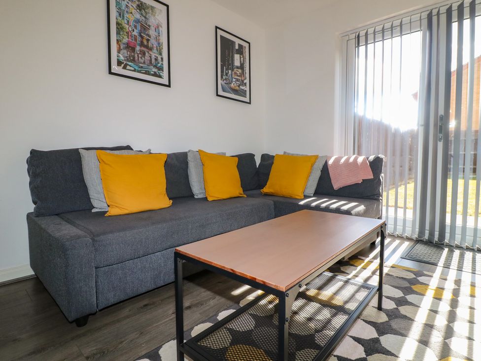 A living room with a sofa and coffee table at 32 Moorland House in Syston