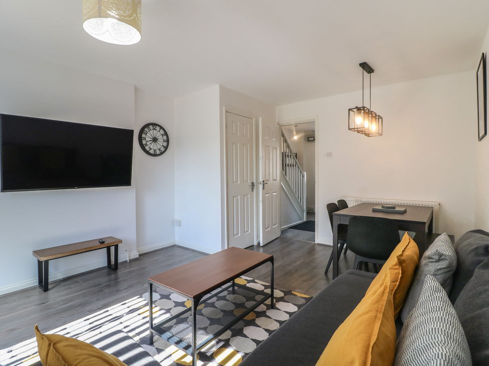 A living room with a television and sofa at 32 Moorland House in Syston