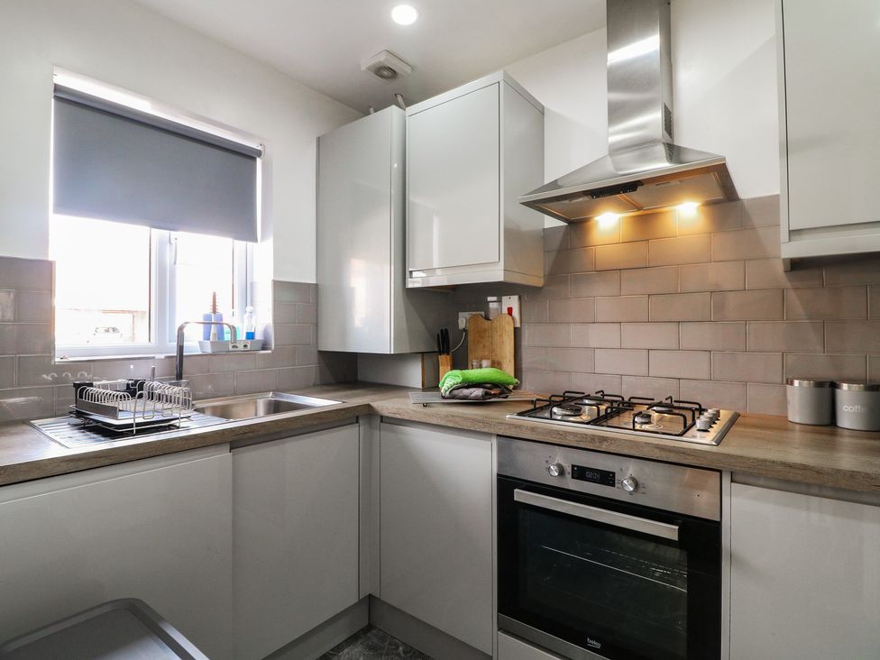 A kitchen with sink and stove at 32 Moorland House Syston