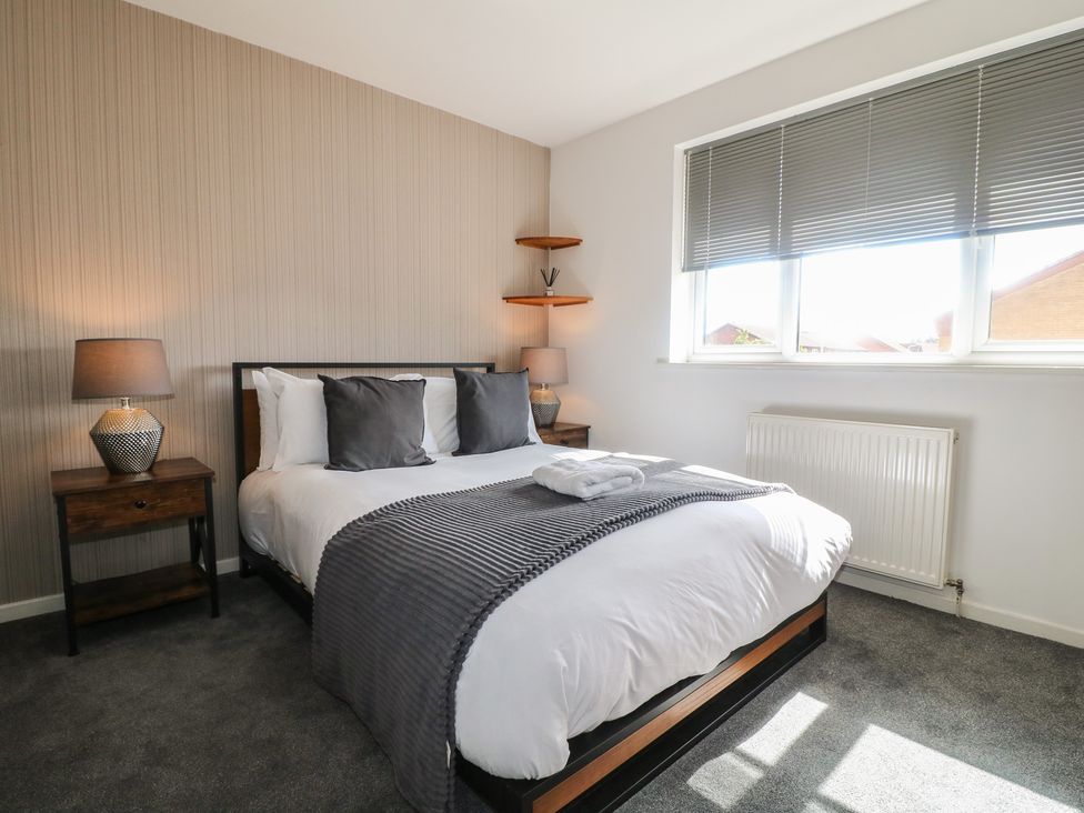 A bedroom with a bed and bedside tables at 32 Moorland House Syston