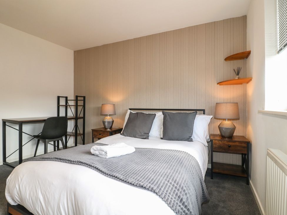 A bedroom with a bed and desk at 32 Moorland House in Syston