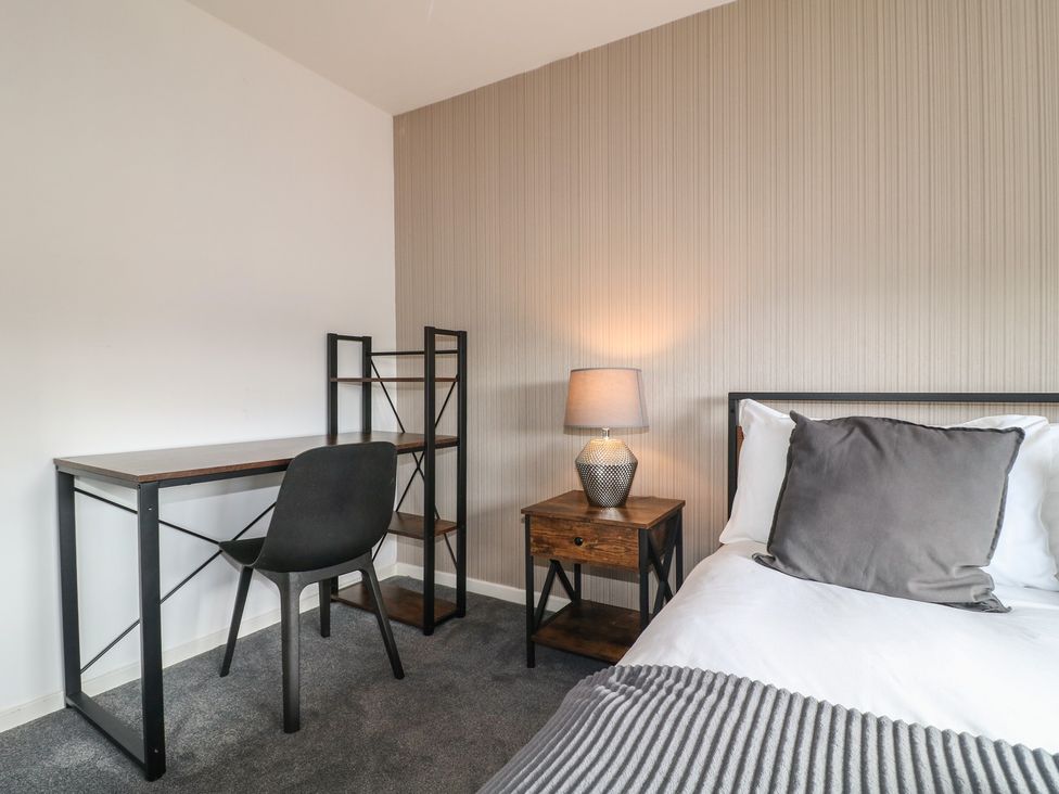 A bedroom with a bed, desk and bookshelf at 32 Moorland House in Syston