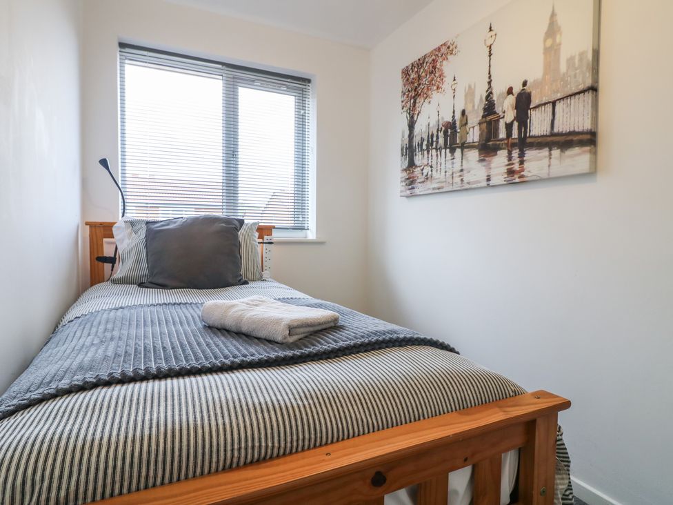 A bedroom with a single bed and wall art at 32 Moorland House Syston