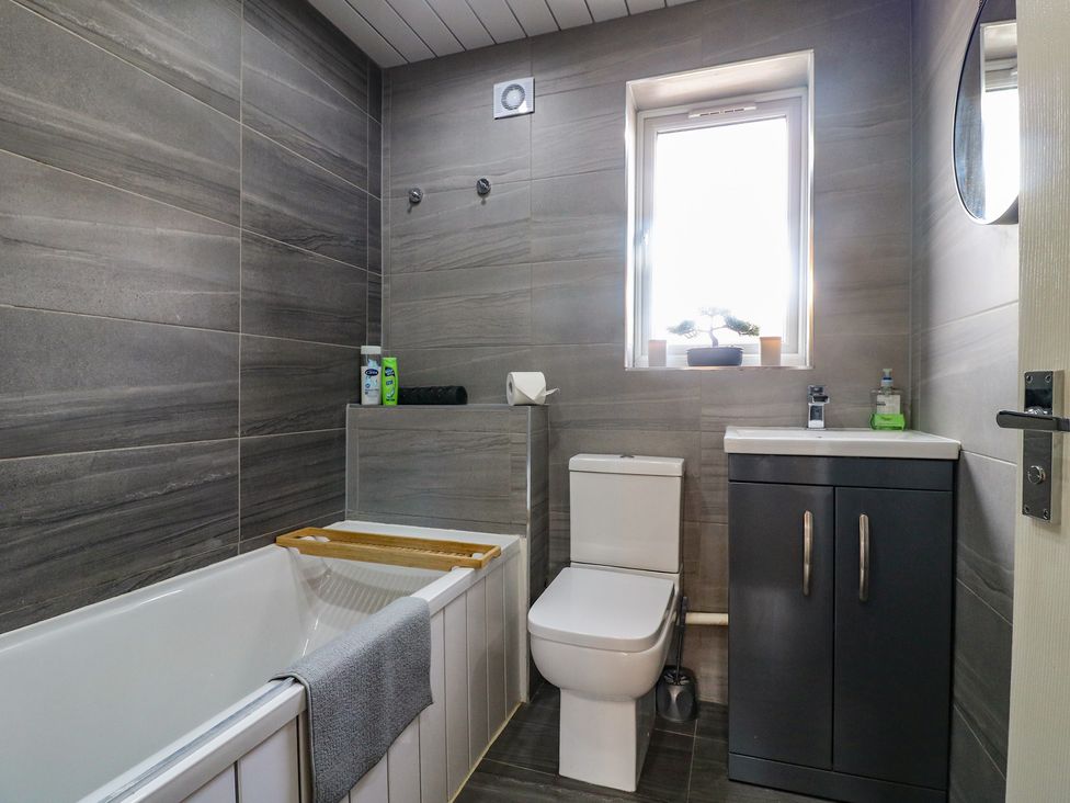 A bathroom with a bathtub, toilet, and sink at 32 Moorland House in Syston