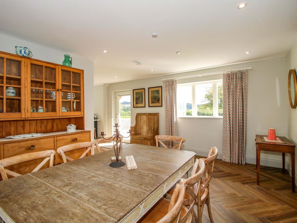 A dining room with a wooden table and chairs at Hoddell Pitch Cottage Kinnerton near New Radnor