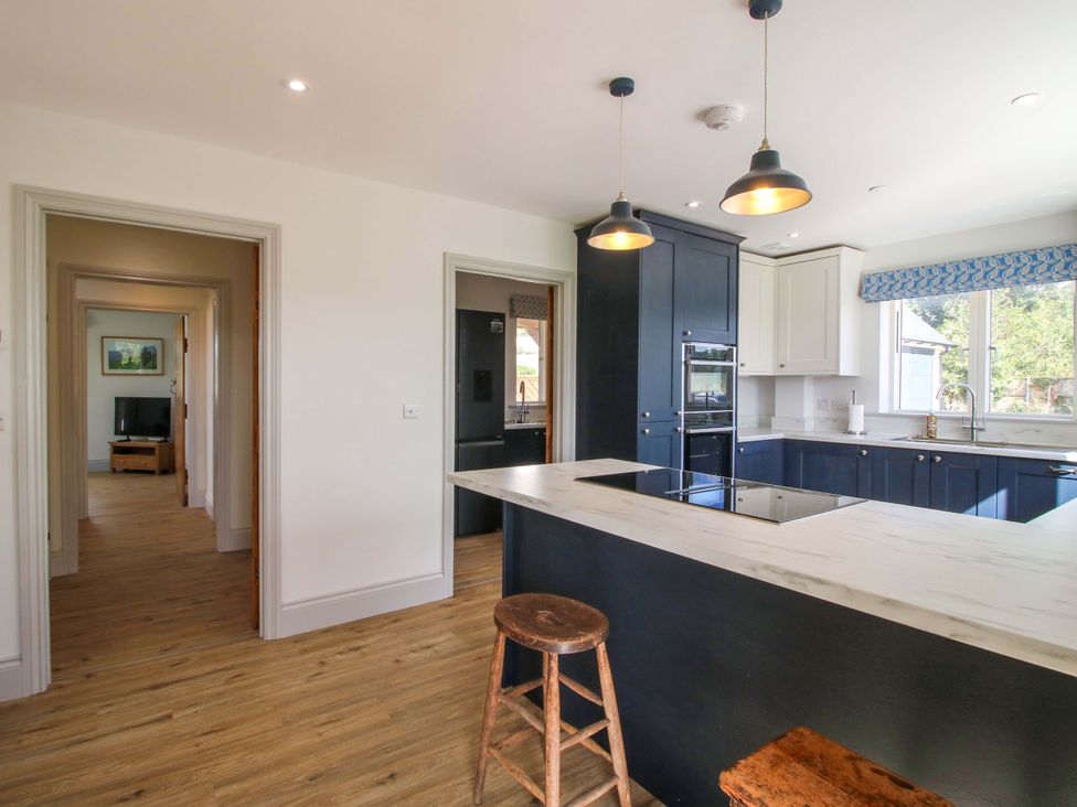 A kitchen with an island and stools at Hoddell Pitch Cottage in Kinnerton near New Radnor