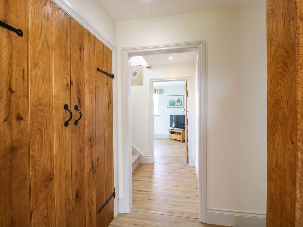 A hallway with wooden doors and a view of a living area at Hoddell Pitch Cottage Kinnerton near New Radnor