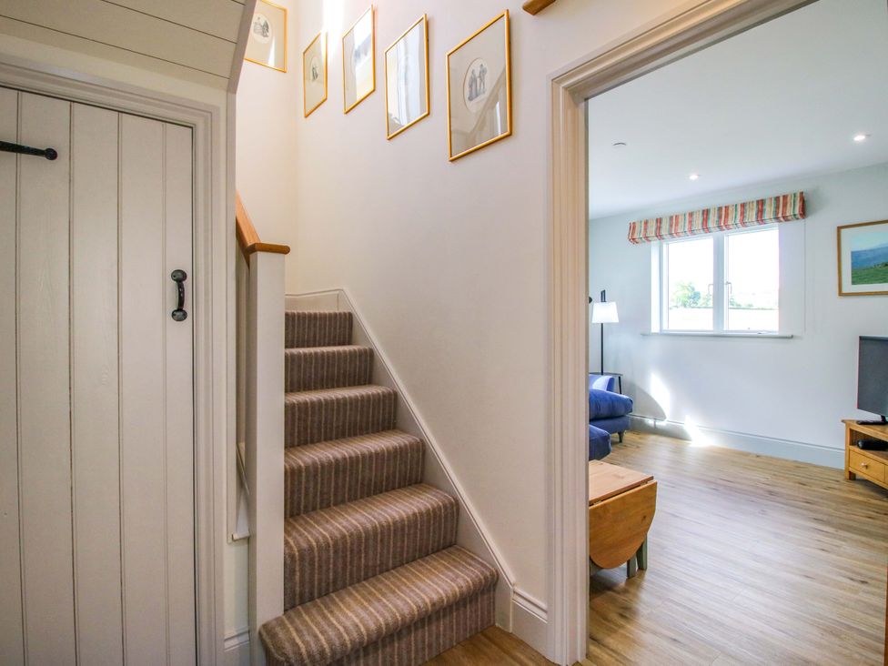 A staircase leading to a living area with a lamp and sofa at Hoddell Pitch Cottage Kinnerton near New Radnor