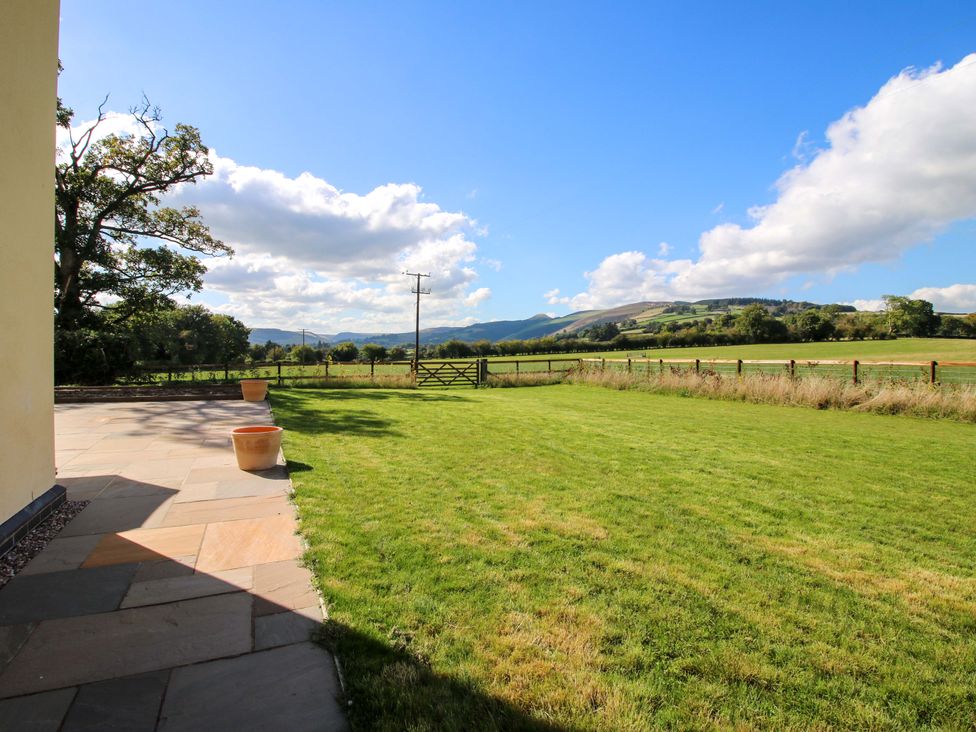 A garden view with grass and mountains at Hoddell Pitch Cottage Kinnerton near New Radnor