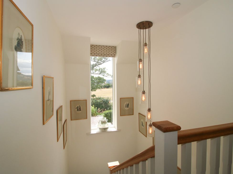 A staircase with wall art and light fixtures at Hoddell Pitch Cottage in Kinnerton near New Radnor