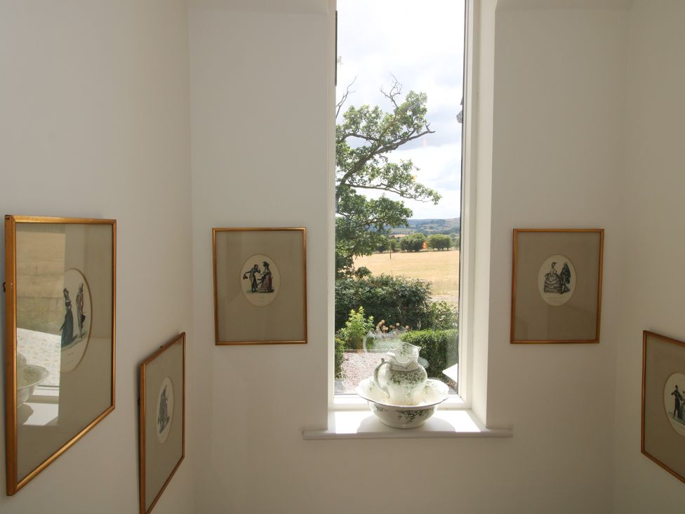 A stairwell with framed pictures and a window at Hoddell Pitch Cottage Kinnerton near New Radnor