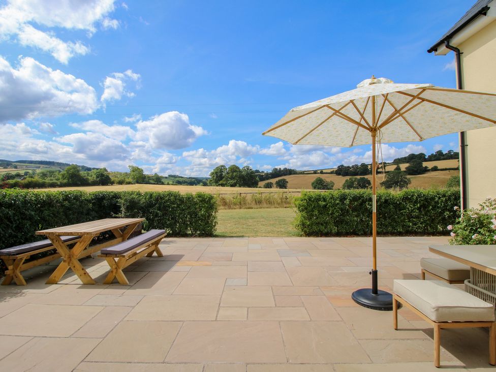 An outdoor seating area with a table and umbrella at Hoddell Pitch Cottage Kinnerton near New Radnor