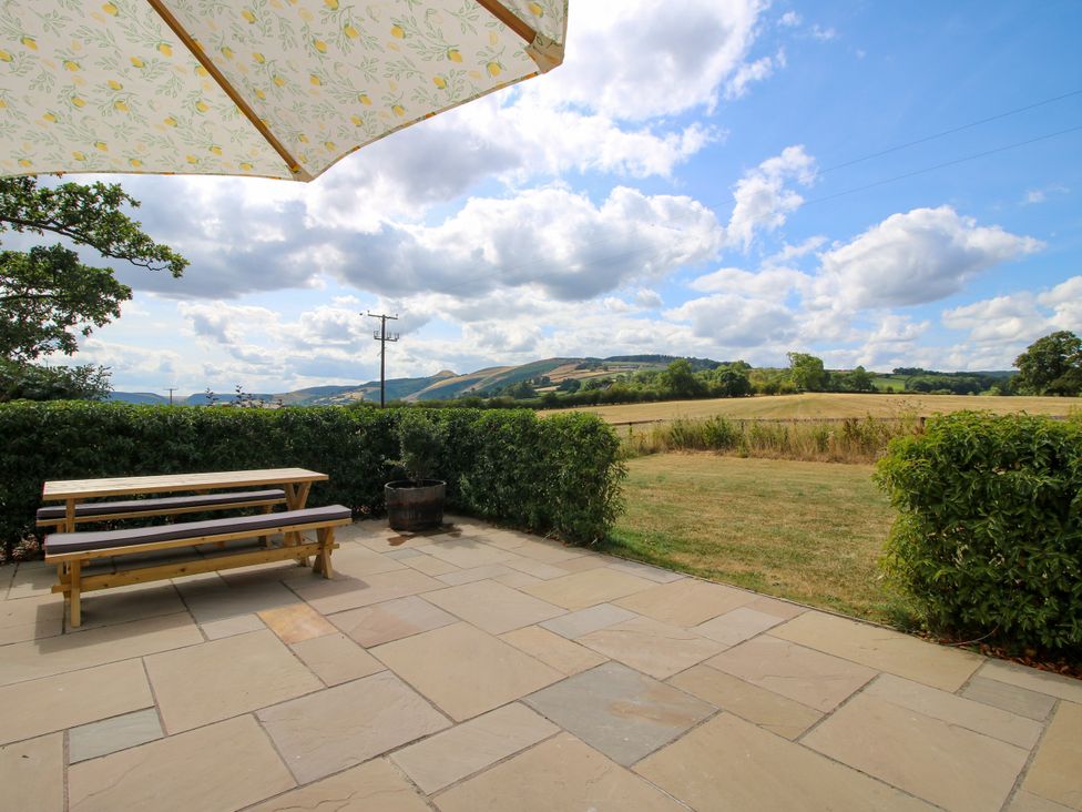 A patio with table and benches at Hoddell Pitch Cottage in Kinnerton near New Radnor