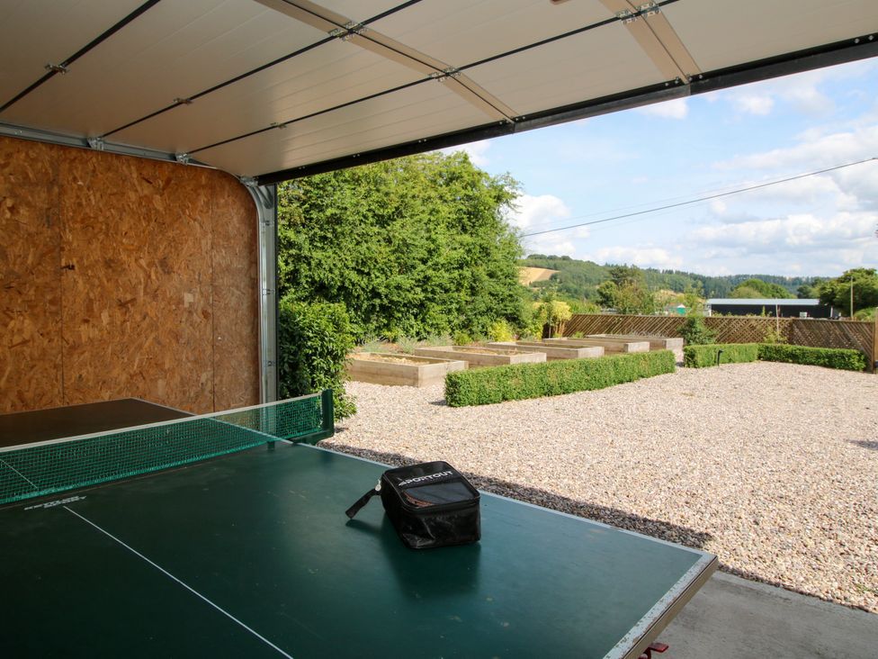 A ping pong table with a bag in a garage at Hoddell Pitch Cottage Kinnerton near New Radnor