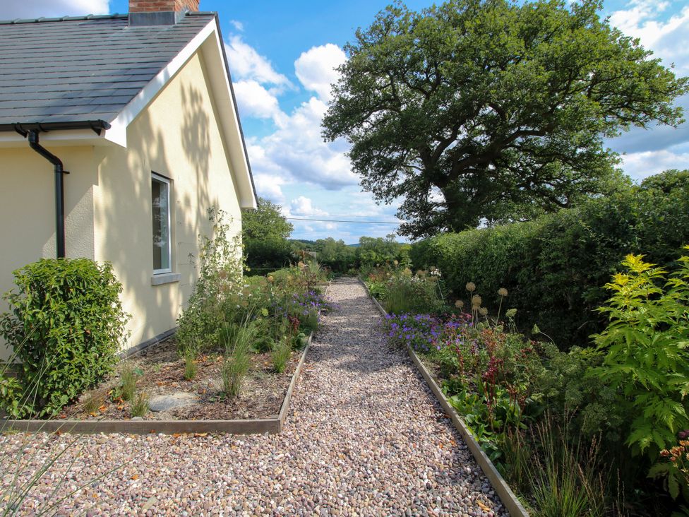 A garden pathway beside a house at Hoddell Pitch Cottage Kinnerton near New Radnor