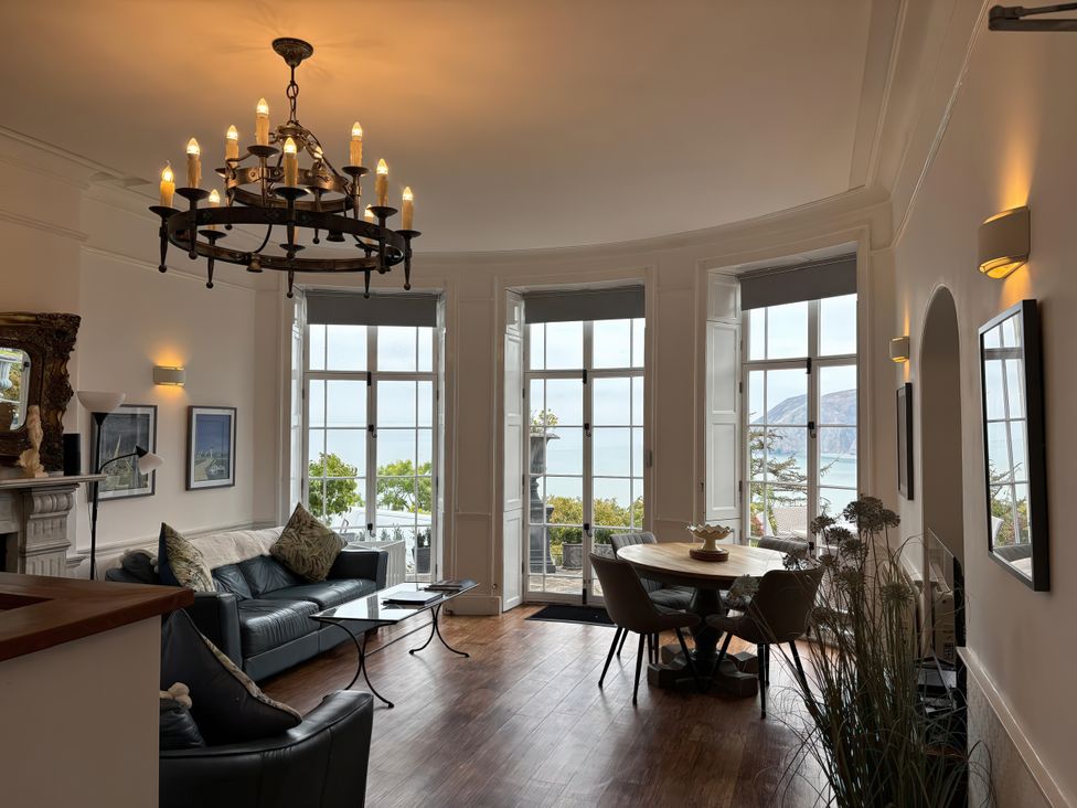 A living room with large windows and a dining area at Bayview Tower in Lynton