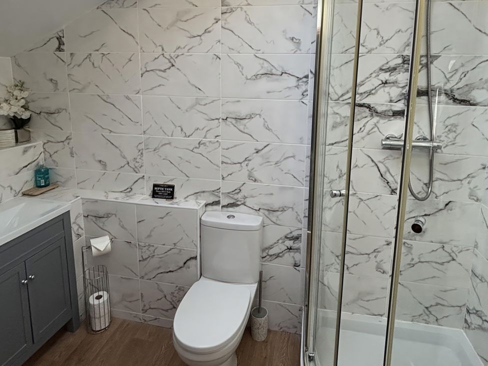 A bathroom with a shower, toilet, and sink at Bayview Tower in Lynton