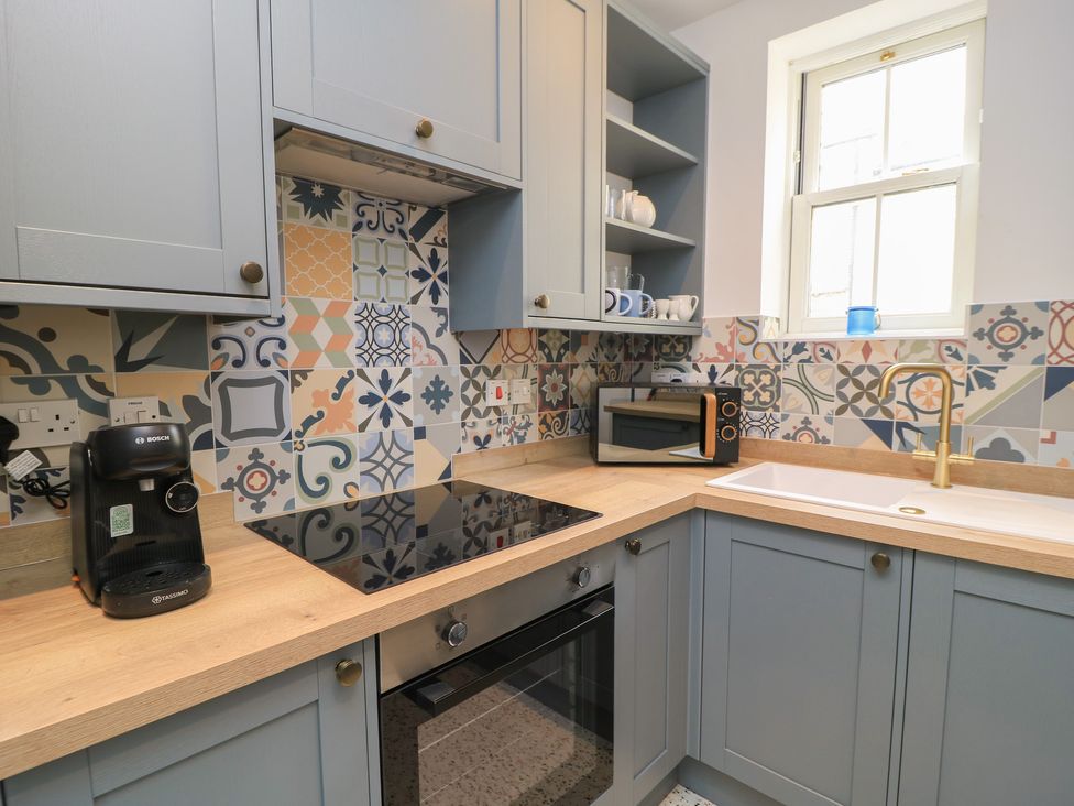 A kitchen with appliances and tiles at Weyside in Weymouth