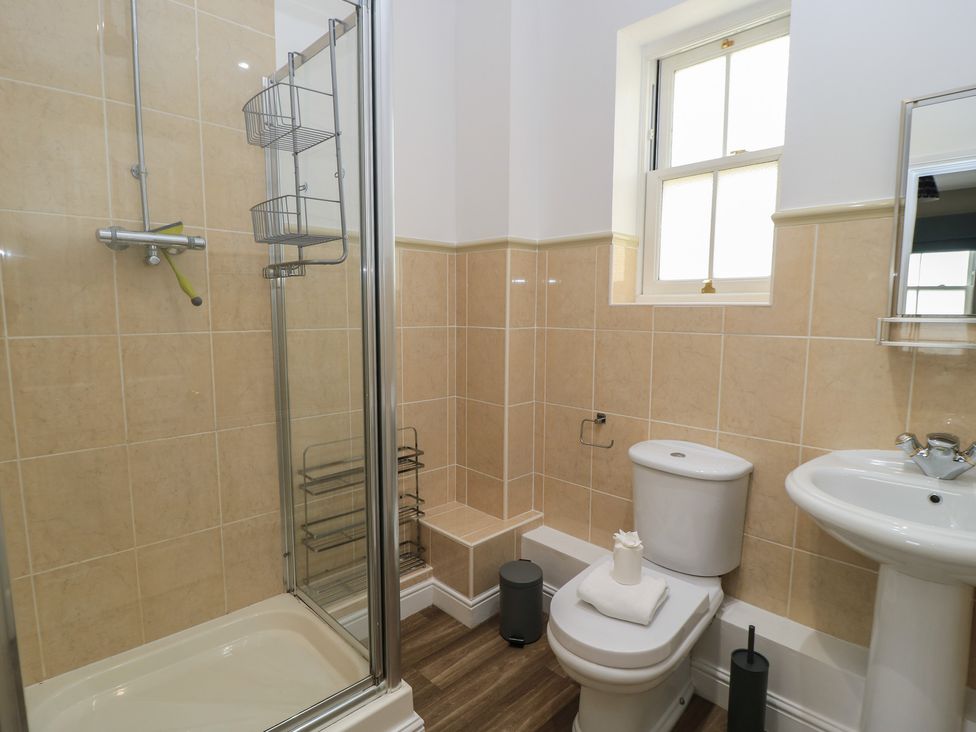 A bathroom with a shower, toilet, and sink at Weyside in Weymouth