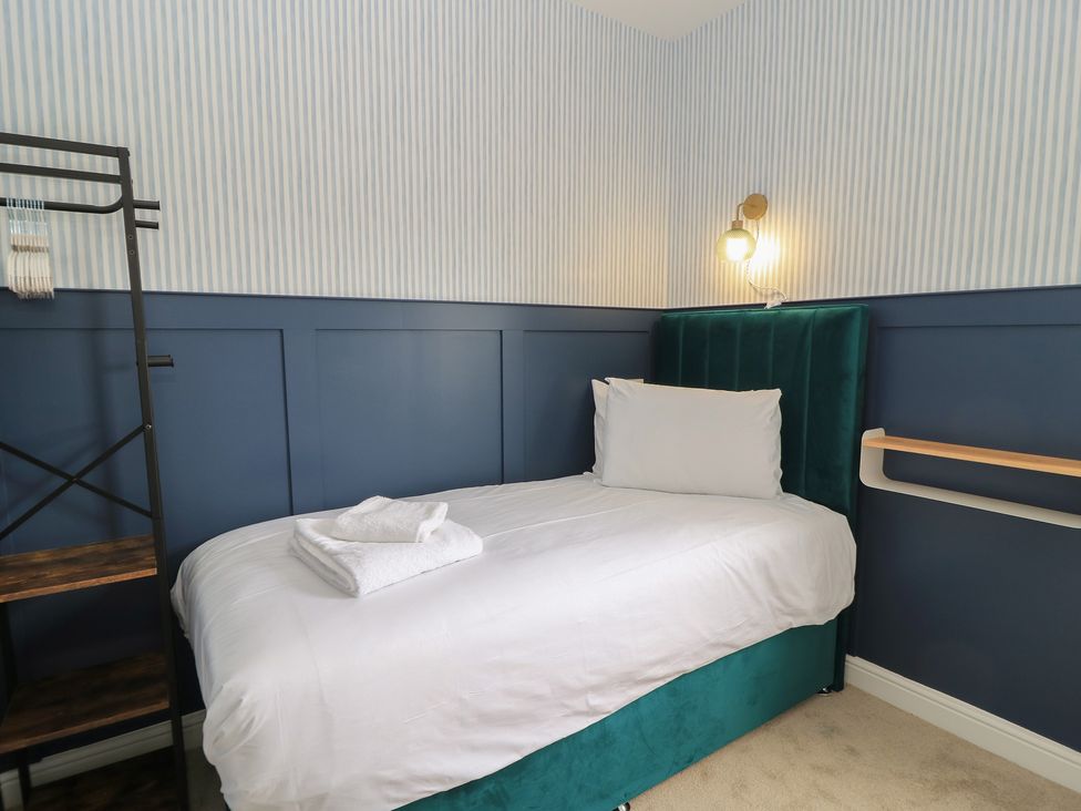 A bedroom with a bed and shelf at Weyside in Weymouth