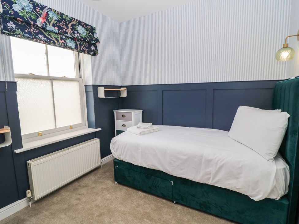 A bedroom with a single bed and window at Weyside in Weymouth