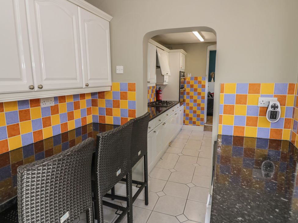 A kitchen with stools and cabinets at Cosy Escape in Birmingham