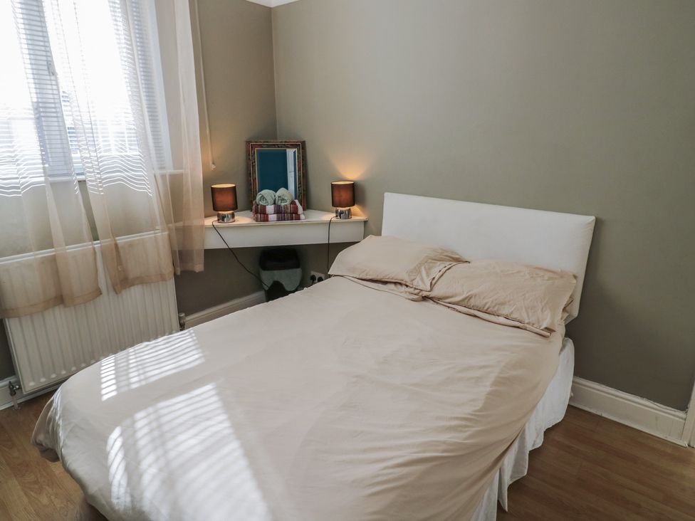 A bedroom with a bed and shelf with lamps at Cosy Escape in Birmingham
