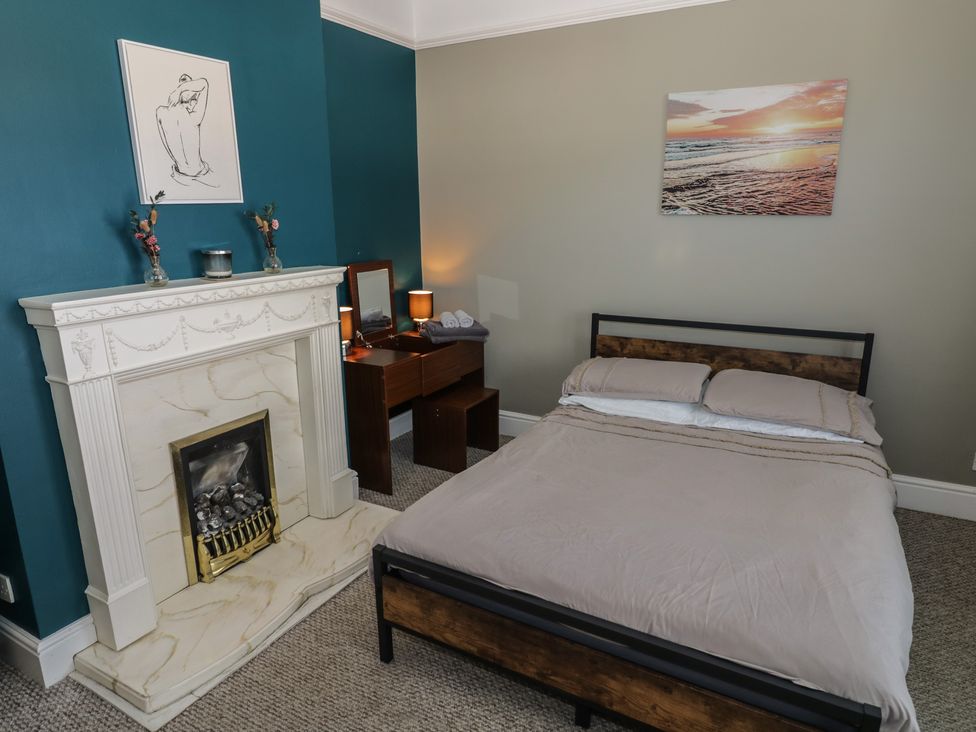 A bedroom with a bed, fireplace, and a table at Cosy Escape in Birmingham