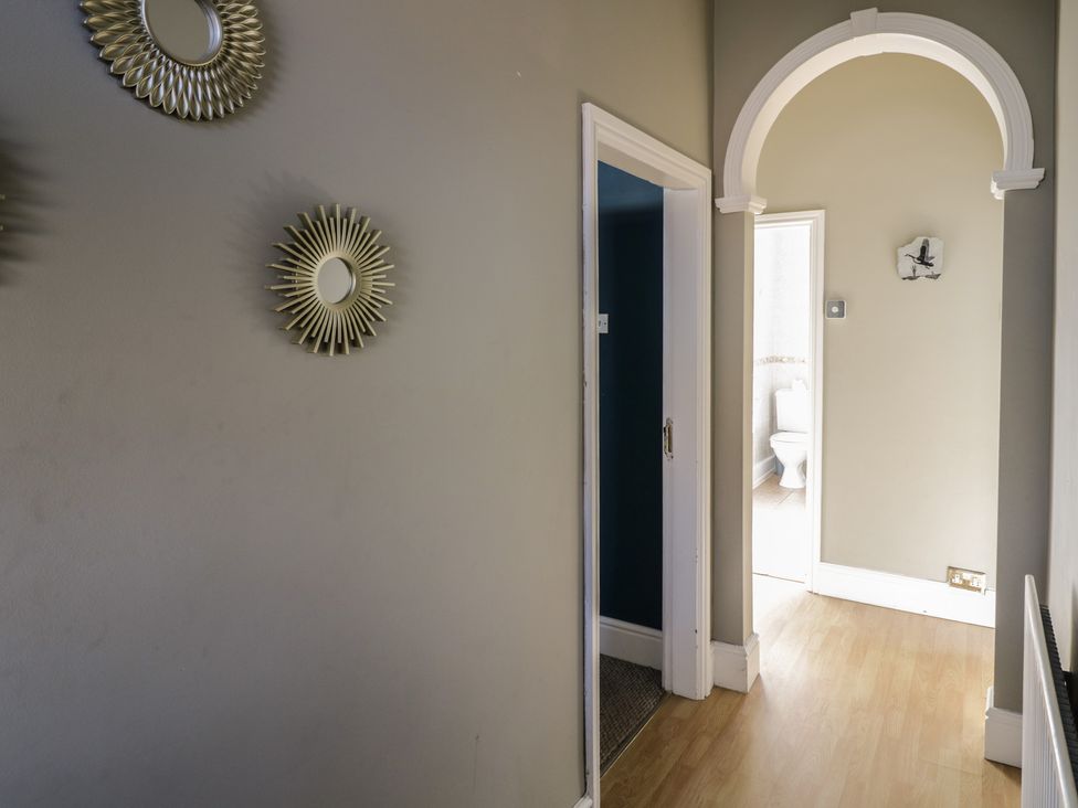 A hallway with mirrors and an archway leading to a bathroom at Cosy Escape in Birmingham