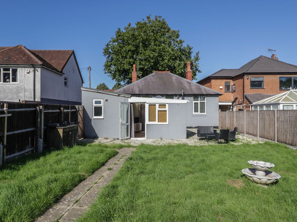 A garden with a house and seating area at Cosy Escape in Birmingham