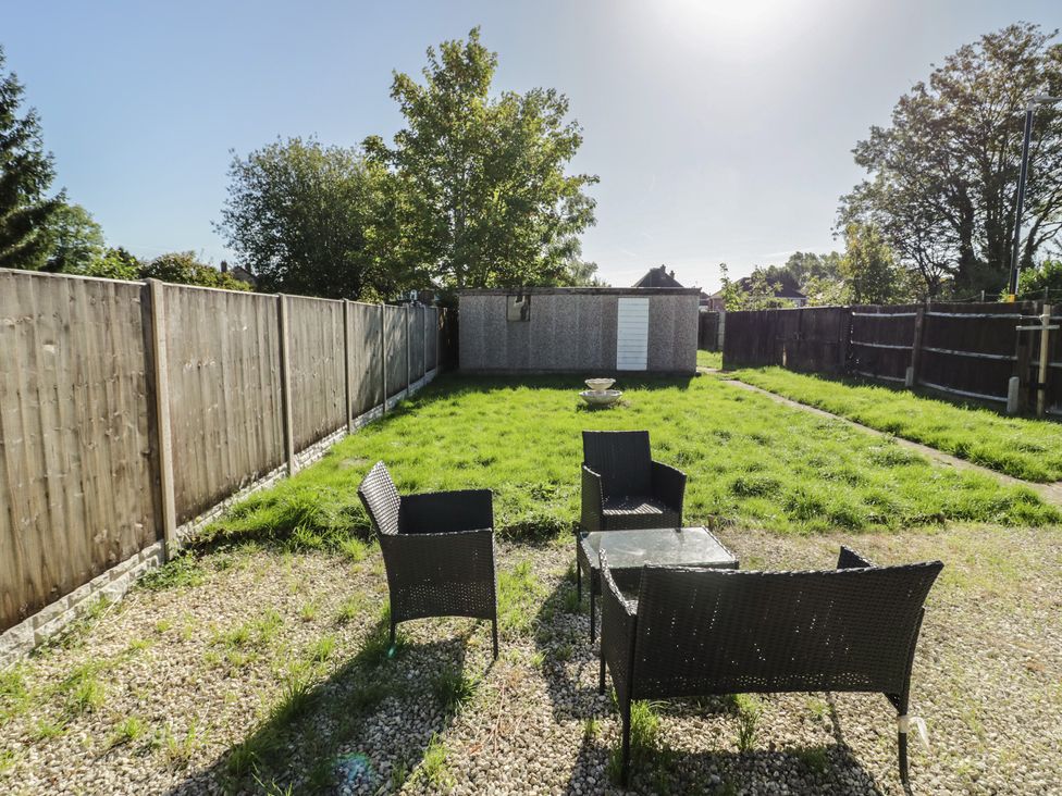 A garden with chairs and a table at Cosy Escape in Birmingham