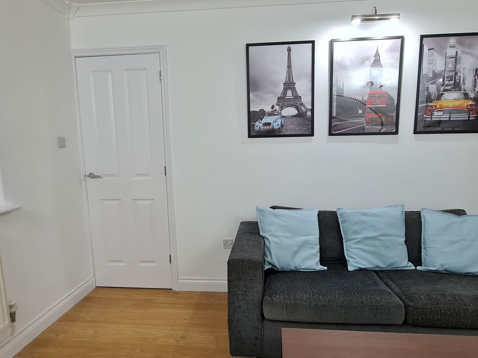 A living room with a sofa and wall art at 12 Gorse Lane in Leicester