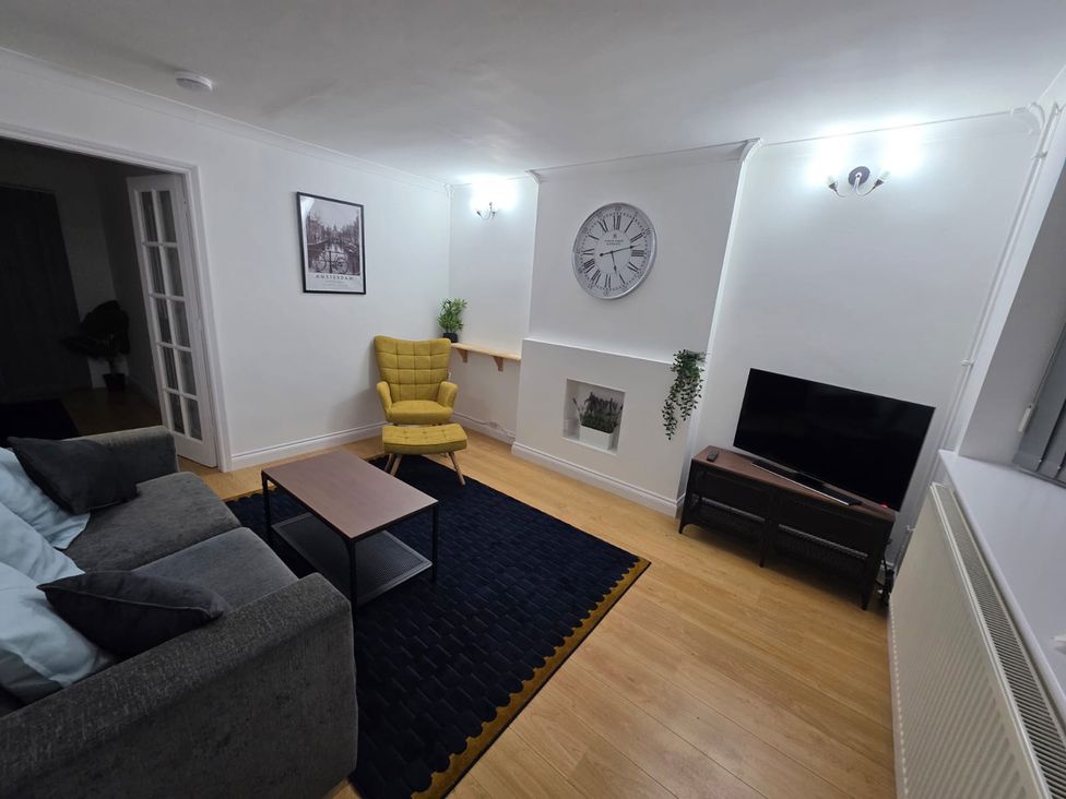 A living room with furniture including a sofa, coffee table, and television at 12 Gorse Lane Leicester
