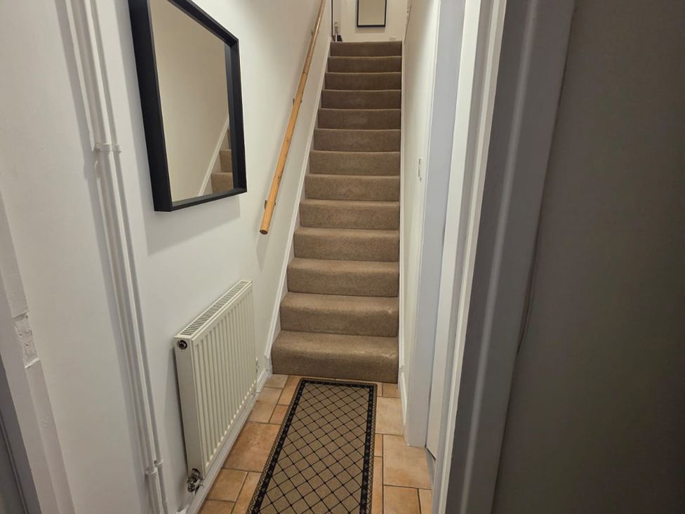 A hallway with stairs and a mirror at 12 Gorse Lane Leicester