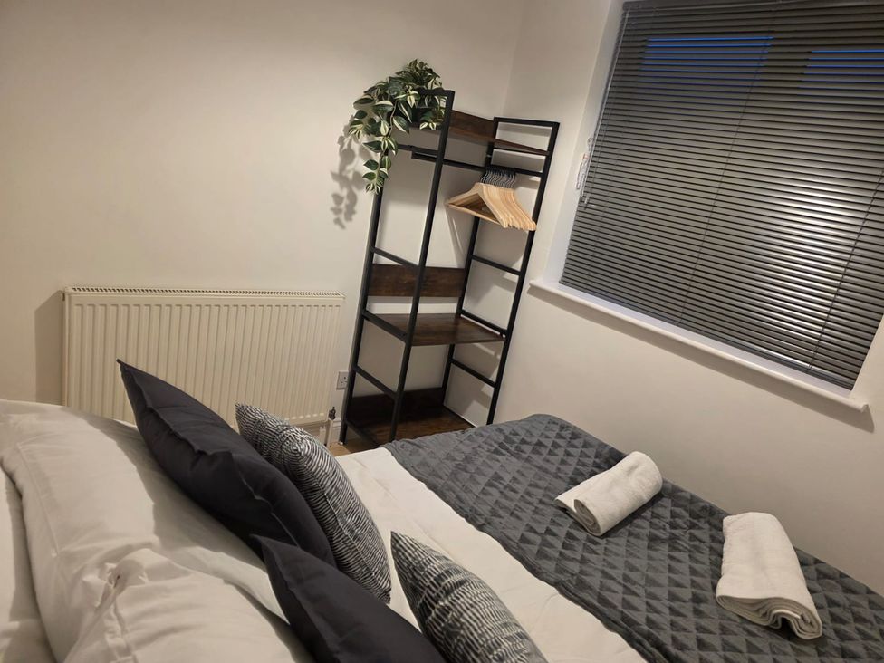 A bedroom with a bed and a shelf at 12 Gorse Lane Leicester