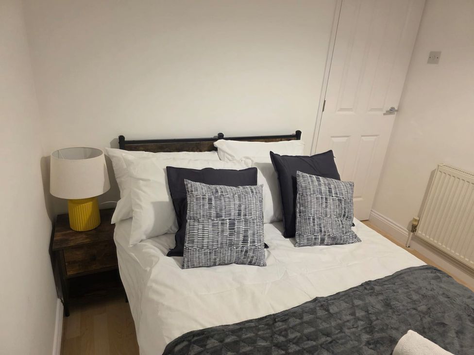 A bedroom with a bed and bedside table at 12 Gorse Lane in Leicester