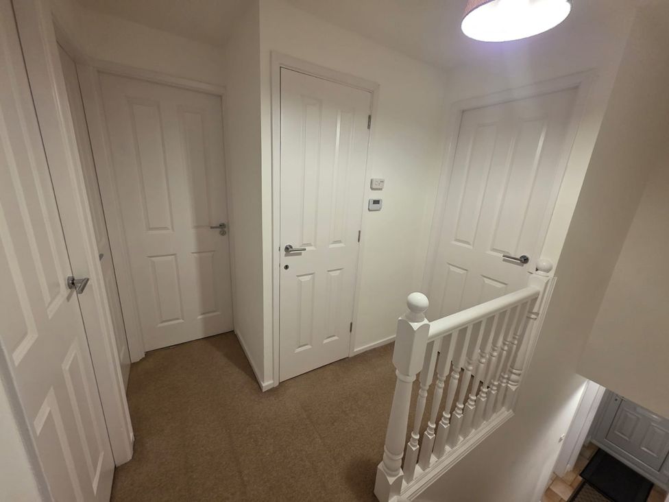 A hallway with doors and a staircase at 12 Gorse Lane Leicester