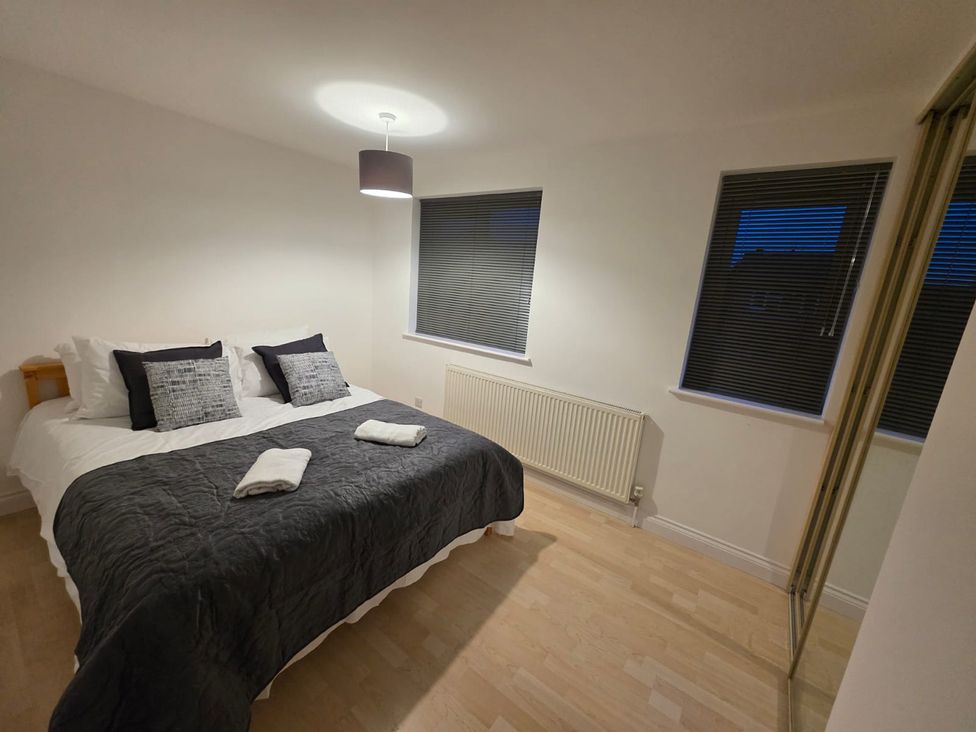 A bedroom with a bed and windows at 12 Gorse Lane Leicester