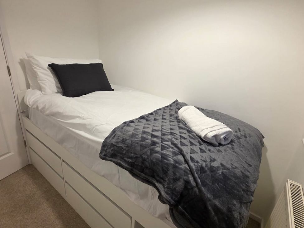 A bedroom with a bed and a towel on top at 12 Gorse Lane, Leicester