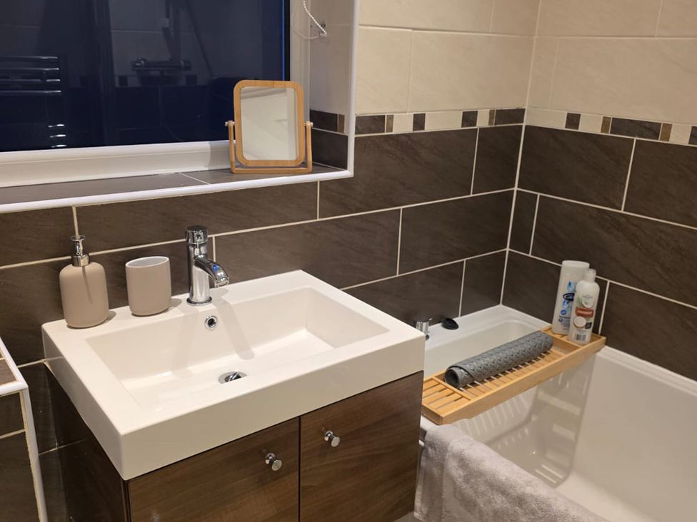 A bathroom with a sink and bathtub at 12 Gorse Lane in Leicester