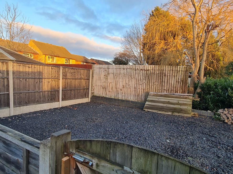 A garden with gravel surface and wooden fence at 12 Gorse Lane Leicester
