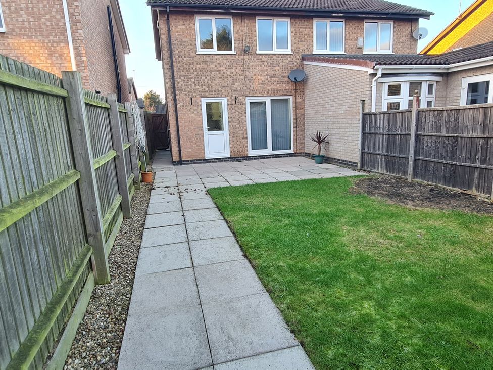 A garden with a patio and green grass at 12 Gorse Lane Leicester