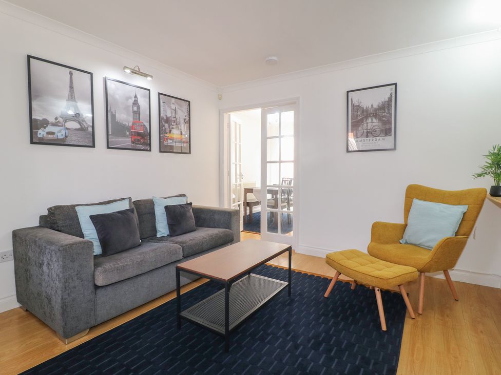 A living room with a sofa and armchair at 12 Gorse Lane in Syston