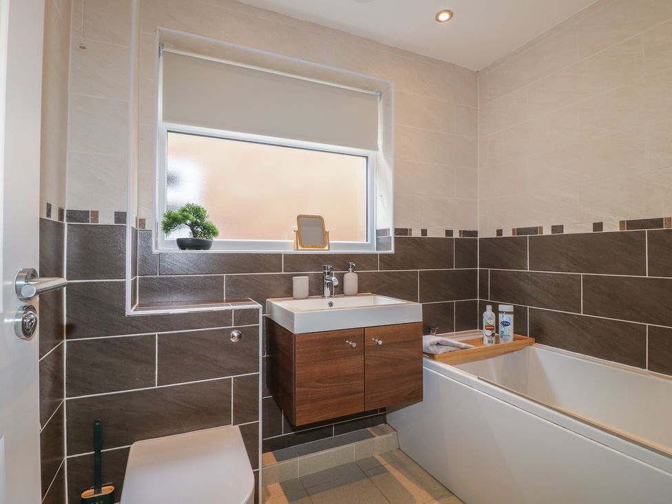 A bathroom with a bathtub and sink at 12 Gorse Lane Syston